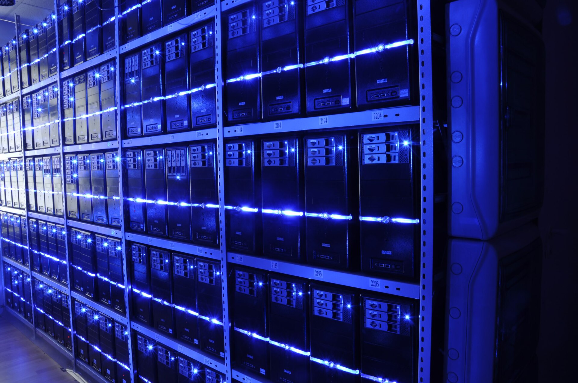 A wall of servers lit by blue LEDs in a data center